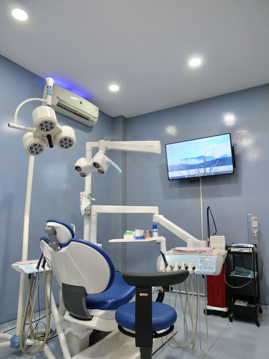 Spacious blue treatment room with advanced dental equipment
